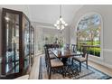 Elegant dining room with large windows, chandelier, and a dark wood china cabinet at 2504 Wertherson Ln, Raleigh, NC 27613