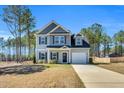 Charming two-story home with attached garage and manicured lawn on a sunny day at 286 Beacon Hill Rd, Lillington, NC 27546