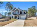 Charming two-story home features a gray exterior, black shutters, attached garage and a well-manicured front lawn at 286 Beacon Hill Rd, Lillington, NC 27546