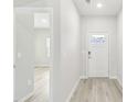 Bright hallway with wood-look flooring, leading to various rooms within the home and a front door with glass at 3405 Rosebush Dr, Zebulon, NC 27597