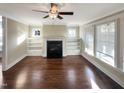 Bright living room featuring hardwood floors, a fireplace with built-in shelving, and large windows at 375 N Serenity Hill Cir, Chapel Hill, NC 27516