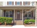Inviting front porch with brick columns, manicured shrubs, and a charming front door at 4108 Overcup Oak Ln, Cary, NC 27519