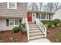 Inviting front porch with white railing leads to a vibrant red front door, enhancing curb appeal at 4209 Converse Dr, Raleigh, NC 27609