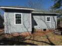 Rear exterior of gray home with white trim featuring a door and modern vinyl siding at 425 S Mercer St, Rocky Mount, NC 27801