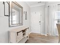 Bright entryway featuring wood-look floors, console table with mirror, and front door at 509 Horseman Park Pl, Wendell, NC 27591
