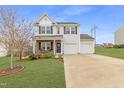 Beautiful two-story home featuring vinyl siding, a well-kept lawn, and a double garage at 509 Horseman Park Pl, Wendell, NC 27591