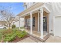Inviting front porch with brick columns and black door with a decorative wreath at 509 Horseman Park Pl, Wendell, NC 27591
