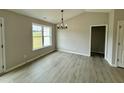 Dining room features wood-look flooring and modern light fixture at 59 Pagani Dr, Kenly, NC 27542