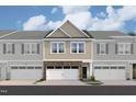Beautifully designed townhome exterior featuring stone accents, neutral siding, and attached two-car garages at 6966 Doddridge Ln # 12, Cary, NC 27519
