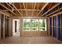 Unfinished room displaying exposed framing and expansive windows offering views of the surrounding greenery at 6966 Doddridge Ln # 12, Cary, NC 27519