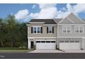 New townhome exterior showcasing stylish design, neutral colors, and attached garages with green lawns at 6968 Doddridge Ln # 11, Cary, NC 27519