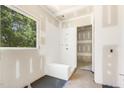 Bright new bathroom with walk-in shower, sleek white bench, and large window with outdoor view at 9000 Penny Rd, Raleigh, NC 27606
