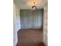 Well-lit room with gray wall paneling, modern light fixture and white french doors offers a versatile space at 9000 Penny Rd, Raleigh, NC 27606