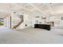 Spacious living room with staircase, kitchen area with black island, and white cabinets at 9000 Penny Rd, Raleigh, NC 27606
