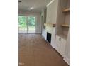 Living room area features a modern fireplace, built-in cabinets, and access to an outdoor balcony at 9000 Penny Rd, Raleigh, NC 27606