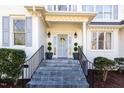 Inviting front entrance with a gray door, black iron railings, and decorative landscaping and potted plants at 9700 Pentland Ct, Raleigh, NC 27614