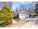 View of the home's backyard featuring a two-car garage and basketball court at 9700 Pentland Ct, Raleigh, NC 27614