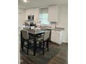 Eat-in kitchen featuring white cabinets, stainless steel appliances, and granite countertops at 103 Crestwater Ct, Louisburg, NC 27549