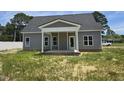 Gray home featuring a covered back porch with white columns and trim at 1039 N Lincoln St, Benson, NC 27504