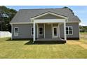 Cozy covered back porch offers shade, relaxation, and direct access to the landscaped backyard at 1039 N Lincoln St, Benson, NC 27504