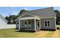 Inviting covered back porch with white columns and ceiling fan, perfect for outdoor relaxation at 1039 N Lincoln St, Benson, NC 27504