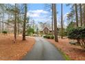 A long driveway leads to a beautiful home surrounded by trees at 10729 Trego Trl, Raleigh, NC 27614