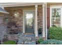 Inviting covered front porch with stone accents and a decorative glass front door at 109 Covington Square Dr, Cary, NC 27513