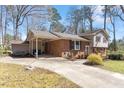 Inviting home with brick facade, large driveway, carport, and well-maintained landscaping at 112 Celeste Cir, Chapel Hill, NC 27517
