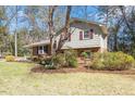 Charming exterior with brick and siding, complemented by lush greenery and mature trees at 112 Celeste Cir, Chapel Hill, NC 27517