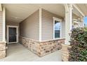Inviting front porch features stone accents, neutral siding and a dark front door at 117 Oak Rise Ln, Fuquay Varina, NC 27526