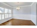 Dining room with hardwood floors, wainscoting, and a stylish light fixture at 121 Homegate Cir, Apex, NC 27502