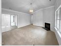 Spacious living room with sliding glass doors, a cozy fireplace, and neutral carpet at 1213 Cotten Farm Dr, Fuquay Varina, NC 27526