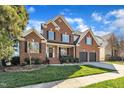 Beautiful two-story brick home featuring a well-kept lawn and a two-car garage at 12404 Beauvoir St, Raleigh, NC 27614