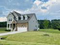 Charming two-story home featuring a combination of stone and siding on a manicured lawn at 125 Scotland Dr, Youngsville, NC 27596