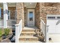 Close-up of the front door, showing stone steps, a white front door with glass, and the house number on the post at 125 Scotland Dr, Youngsville, NC 27596