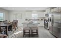 Open-concept kitchen with island seating, stainless appliances, and a view into the dining area at 14 Artesa Ct, Fuquay Varina, NC 27526