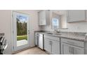 Well-lit kitchen with stainless steel dishwasher, granite countertops, and access to the backyard at 168 Starlight St, Sanford, NC 27330