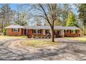 Classic single-story brick home with flowering trees and well-manicured landscaping at 1704 Cypress Dr, Henderson, NC 27536