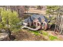 Stunning aerial view of red brick home surrounded by lush greenery and a golf course at 199 Black Cloud Dr, Louisburg, NC 27549