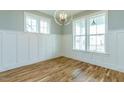 Bright dining room featuring hardwood floors, white wainscoting, and a modern chandelier at 201 Bluffwood Avenue, Chapel Hill, NC 27516