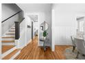Inviting foyer with hardwood floors, a staircase with dark railing, and decorative table with plant at 201 Bluffwood Avenue, Chapel Hill, NC 27516