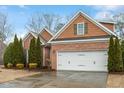 Single-story brick home with a two-car garage, pretty shrubbery and a well-manicured lawn at 201 Hales Wood Rd, Chapel Hill, NC 27517