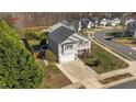 Aerial view of a two-story home with gray siding, a two-car garage, and manicured lawn in a residential neighborhood at 201 Oakton Ridge Pl, Garner, NC 27529