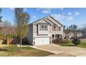 Two-story home with gray siding, stone accents, two-car garage, and well-manicured lawn on a clear day at 201 Oakton Ridge Pl, Garner, NC 27529