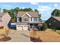 Charming two-story home featuring stone accents, a covered porch, and a two-car garage at 253 Bendemeer Ln, Rolesville, NC 27571