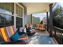 Cozy front porch with colorful striped seating and a decorative outdoor rug at 253 Bendemeer Ln, Rolesville, NC 27571
