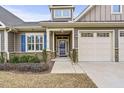 Welcoming entryway with stone accents, an attached garage, and a beautiful front door at 255 Thornwhistle Pl, Garner, NC 27529