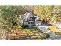 An aerial view of a beautiful home nestled among mature trees, showcasing its spacious lot and long driveway at 260 Crestdale Dr, Clayton, NC 27520
