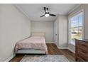 Cozy bedroom featuring hardwood floors, a ceiling fan, and a large window with natural light at 309 Old Farm Dr, Graham, NC 27253