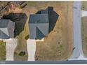Aerial view of a house with a dark roof, a long driveway, and a well-kept lawn at 3517 Glade Run Dr, Sanford, NC 27330